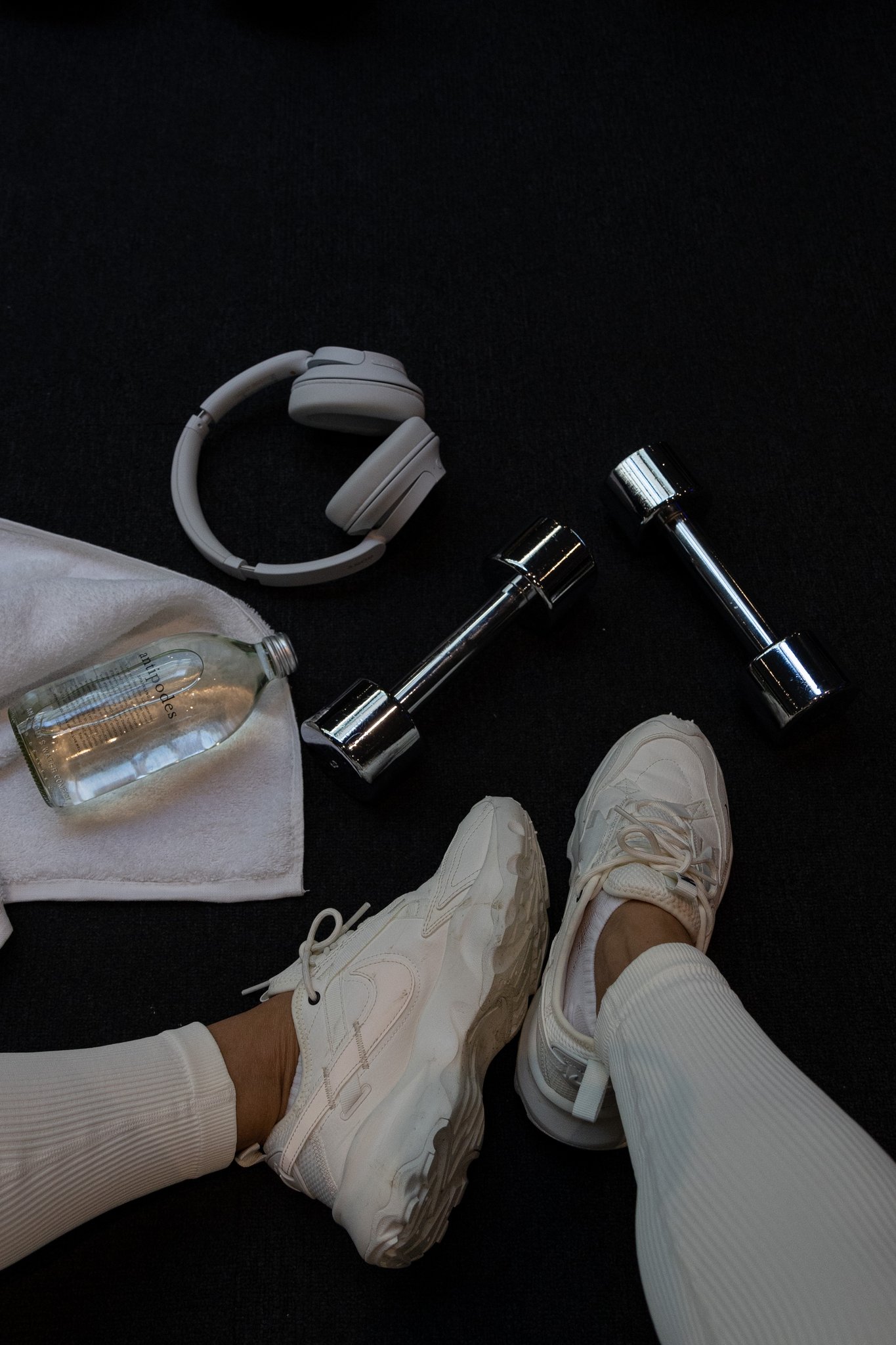 Overhead flat lay of fitness essentials and sportswear on black