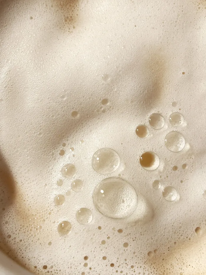 Bubbles and foam on creamy beige textured surface
