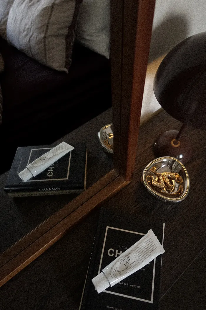Luxury skincare products and gold accessories on dark surface