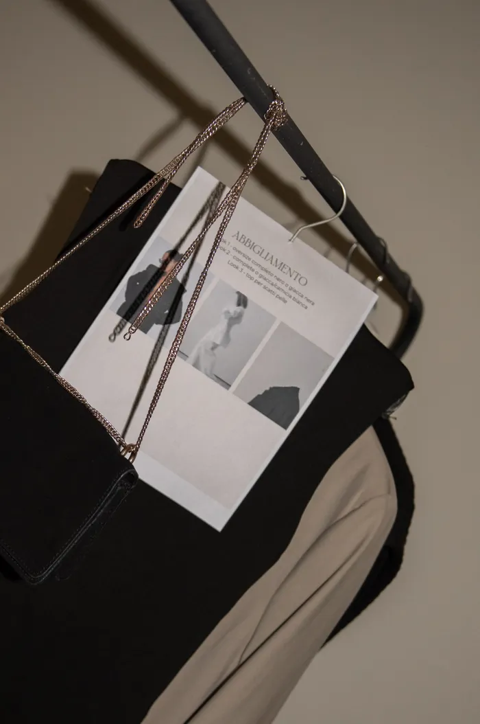 Lookbook with hang tags on a black clothing rack