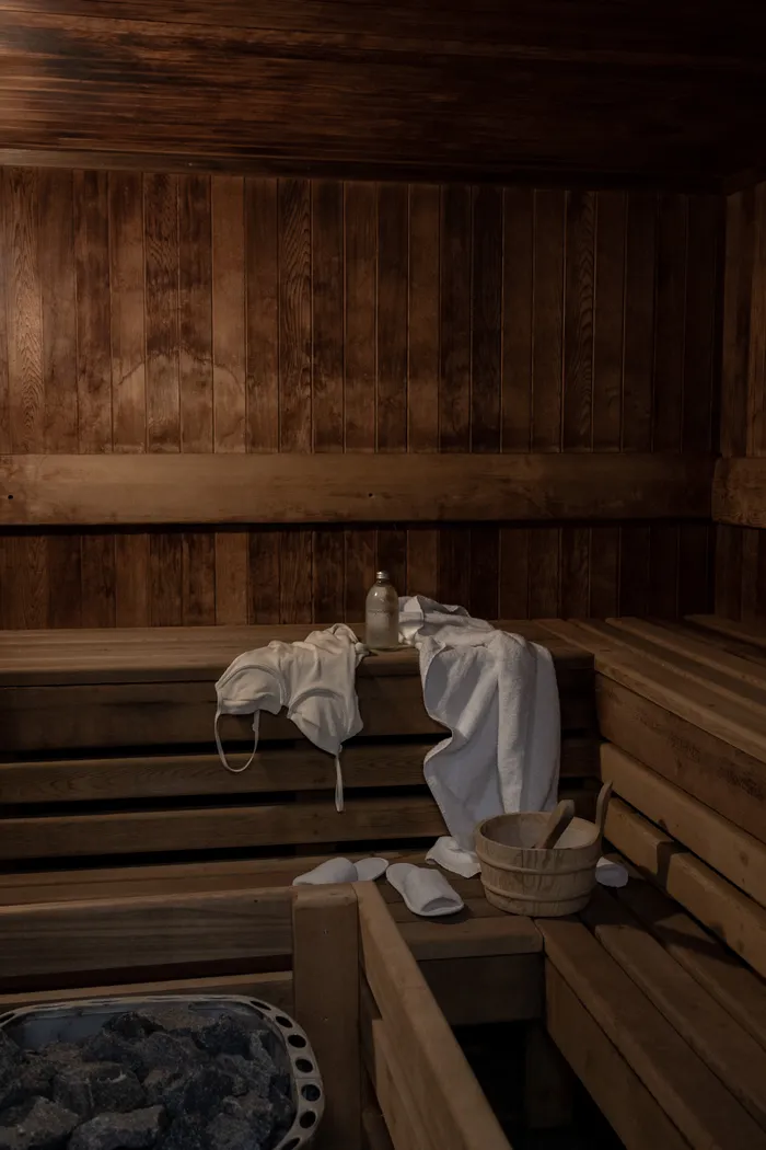 Traditional wooden sauna interior with white linens and accessories