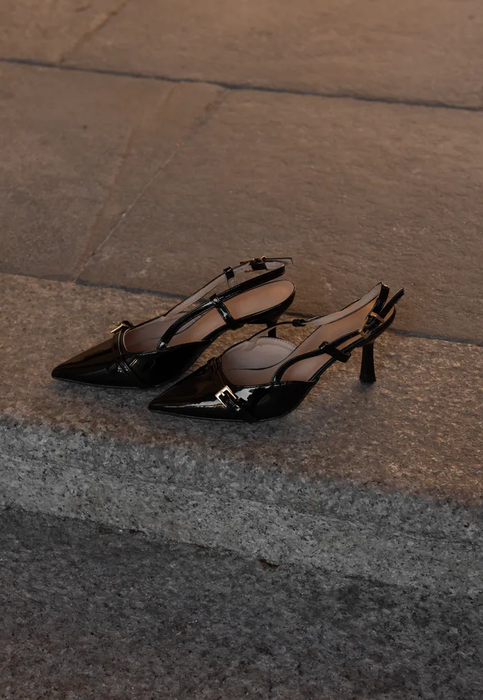 Black slingback heels on concrete pavement